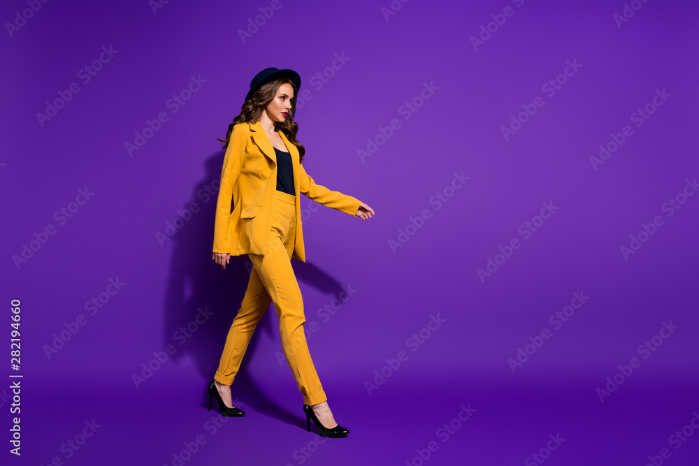 Profile side full length body size view of her she nice-looking glamorous attractive lovely content luxurious wavy-haired lady strolling isolated over bright vivid shine violet lilac background Profile side full length body size view of her she nice-looking glamorous attractive lovely content luxurious wavy-haired lady strolling isolated over bright vivid shine violet lilac background