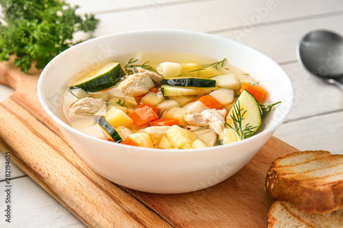 Bowl of tasty soup on wooden table