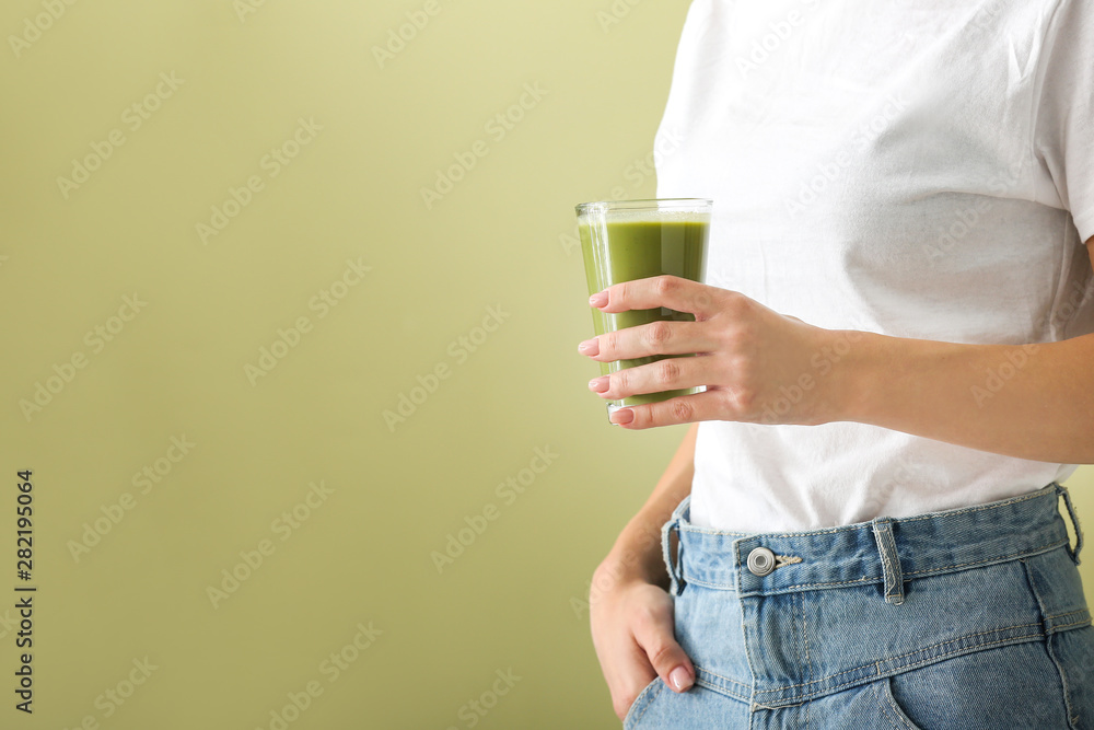 Young woman with tasty smoothie in glass on color background, closeup Young woman with tasty smoothie in glass on color background, closeup