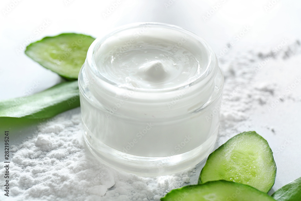 Jar of body cream and cucumber slices on white background, closeup Jar of body cream and cucumber slices on white background, closeup