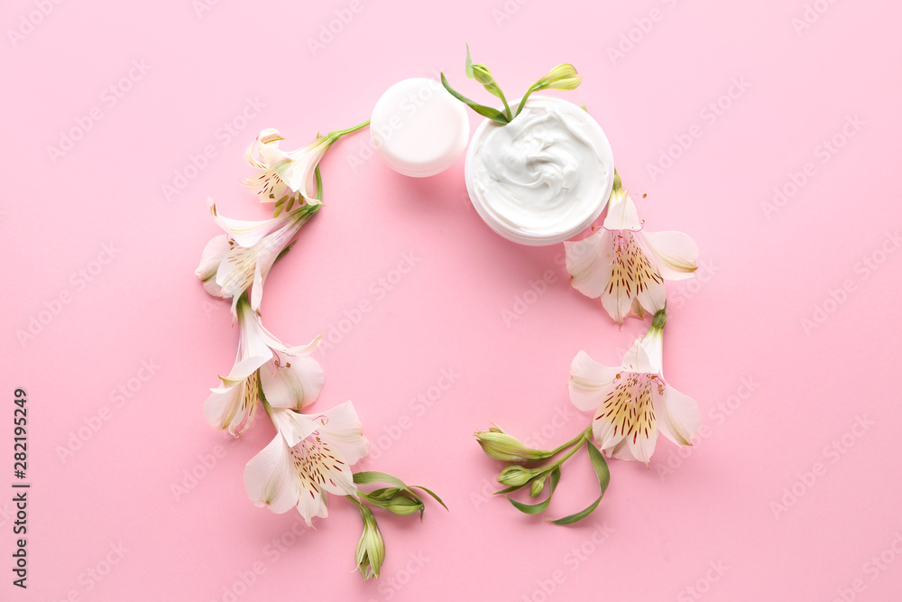 Frame made of natural cream with flowers on color background Frame made of natural cream with flowers on color background