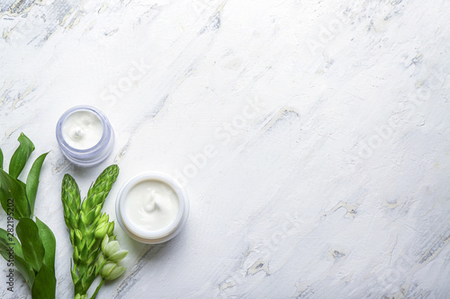 Jars of body cream on white background