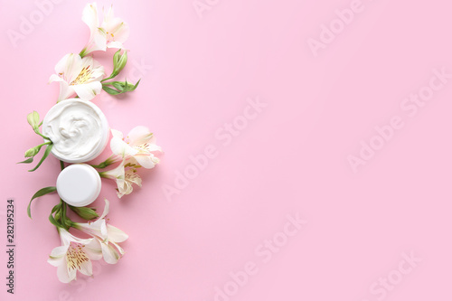 Natural cream with flowers on color background