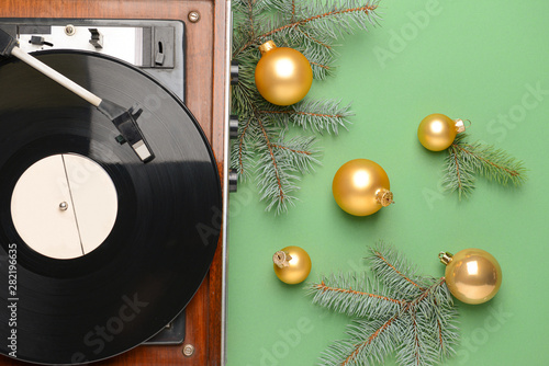 Record player and Christmas decor on color background