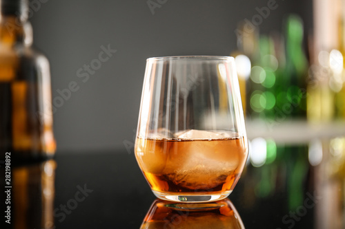 Glass of whiskey on table in bar