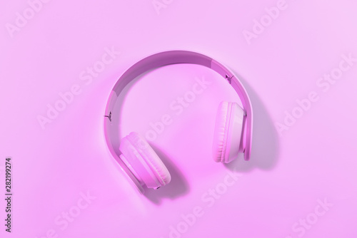 Modern headphones on color background