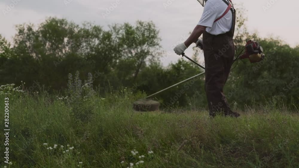 Male gardener working with professional equipment in garden Male gardener working with professional equipment in garden