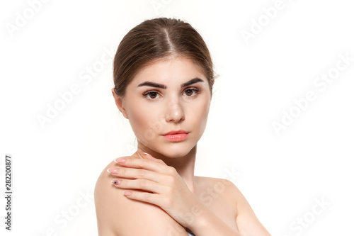 Close-up portrait of a beautiful young girl with holding hands near face isolated over white background.