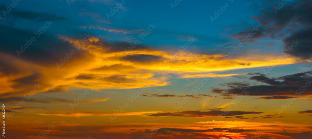 Fototapeta Beautiful Sunset in the sky with sky blue and orange light of the sun through the clouds in the sky, Orange and red dramatic colors - Image