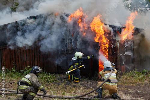Firefighters extinguish a fire in a garage