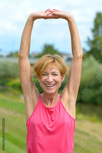 Happy vivacious woman stretching her arms