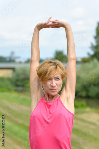 Serious vivacious woman stretching her arms