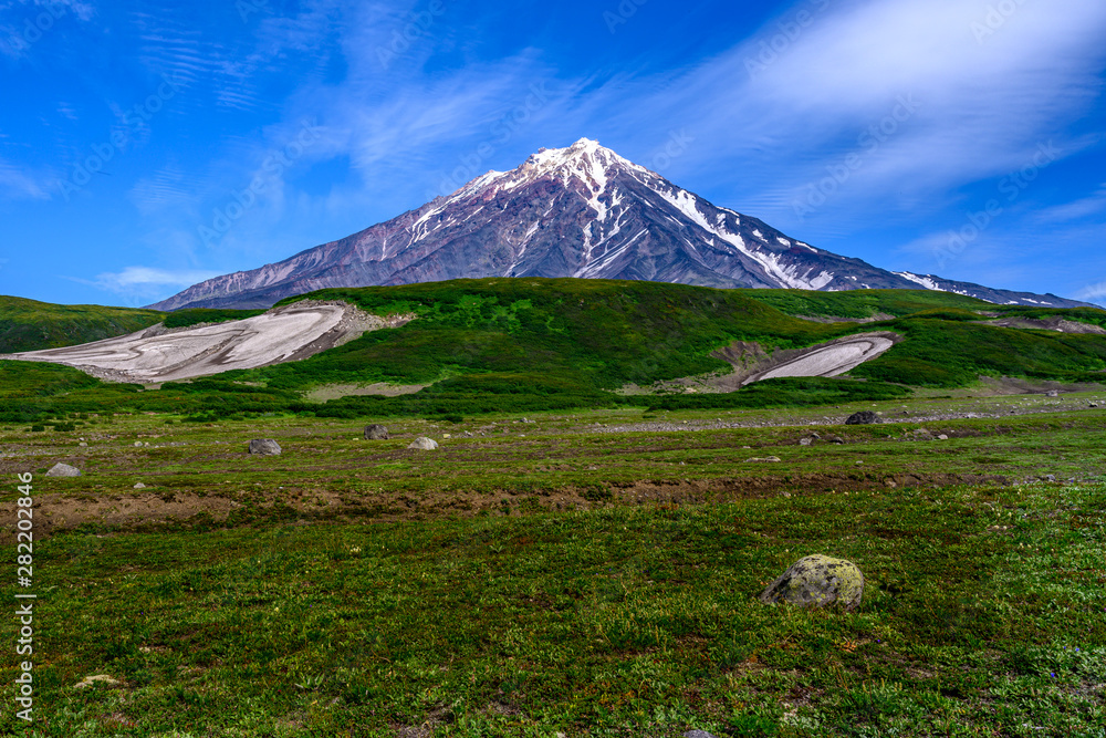 Fototapeta premium Panoramic view of the city Petropavlovsk-Kamchatsky and volcanoes: Koryaksky Volcano, Avacha Volcano, Kozelsky Volcano. Russian Far East, Kamchatka Peninsula.