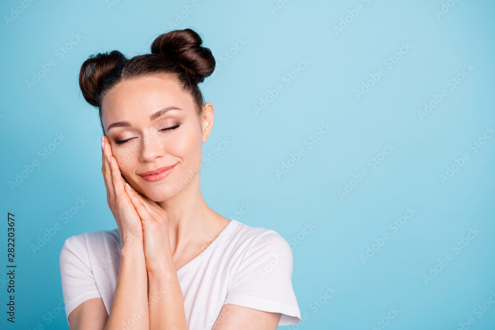 Pretty lady holding both arms on cheek eyes closed silky skin wear white casual t-shirt isolated blue background Pretty lady holding both arms on cheek eyes closed silky skin wear white casual t-shirt isolated blue background