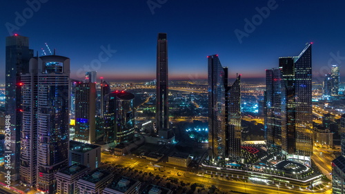 Dubai downtown skyline with tallest skyscrapers and traffic on highway night to day timelapse