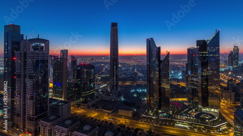Dubai downtown skyline with tallest skyscrapers and traffic on highway night to day timelapse