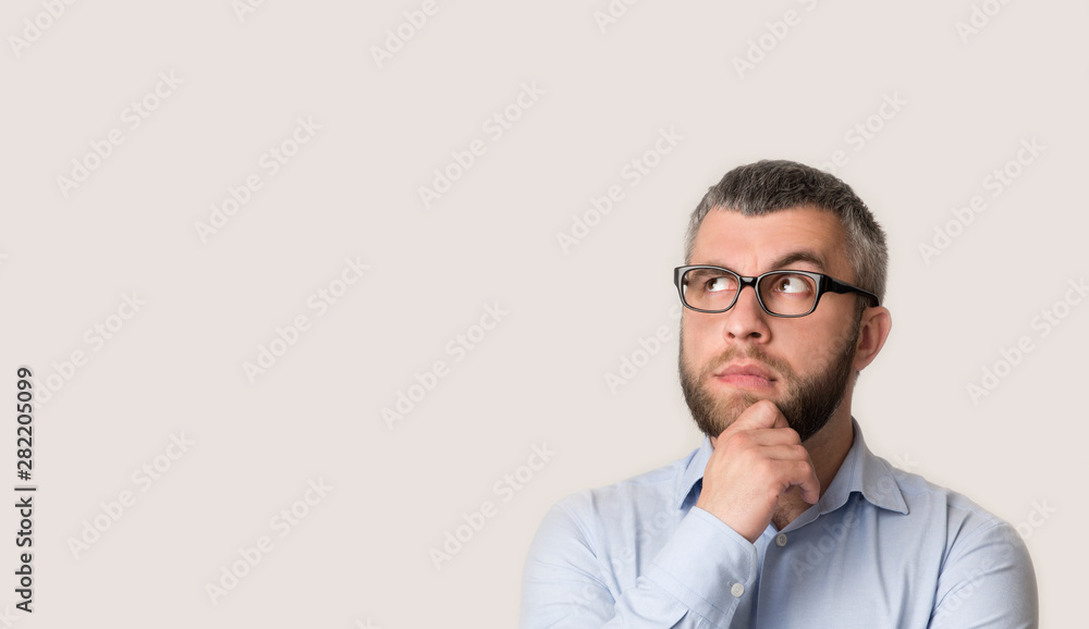 Thinking middle-aged bearded businessman is looking away