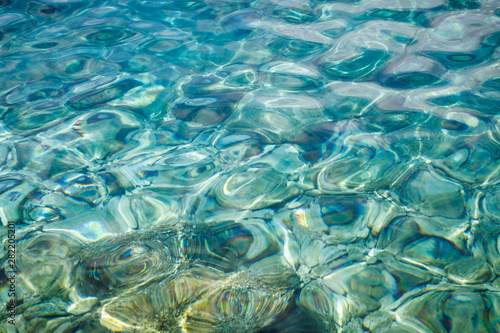 Turquoise sea surface with transparent shallow water - pebbles  stones  rocks on the seabed