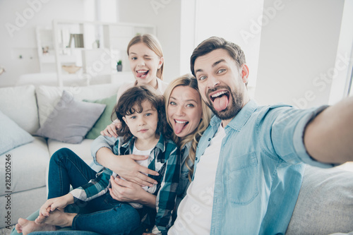 Photo of family two children making selfies weekend great mood sticking tongue out mouth best friends