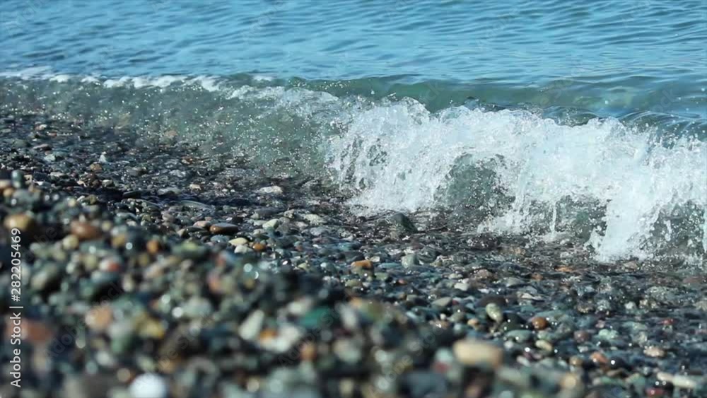 Water texture Waves azure blue sea and stone beach. Water texture Waves azure blue sea and stone beach.