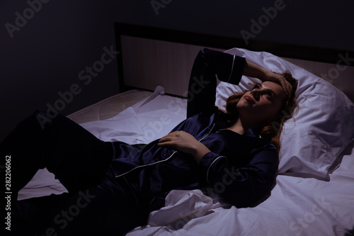 Obraz na płótnie Sleepless female in the bed in the dark. Insomnia at home concept