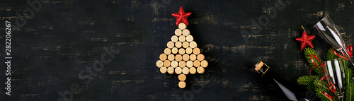 New Year decoration with christmas tree made of wine corks and bottle of champagne. Christmas background. Top view.