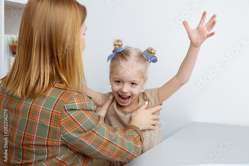 Mother tickling daughter and playing with her