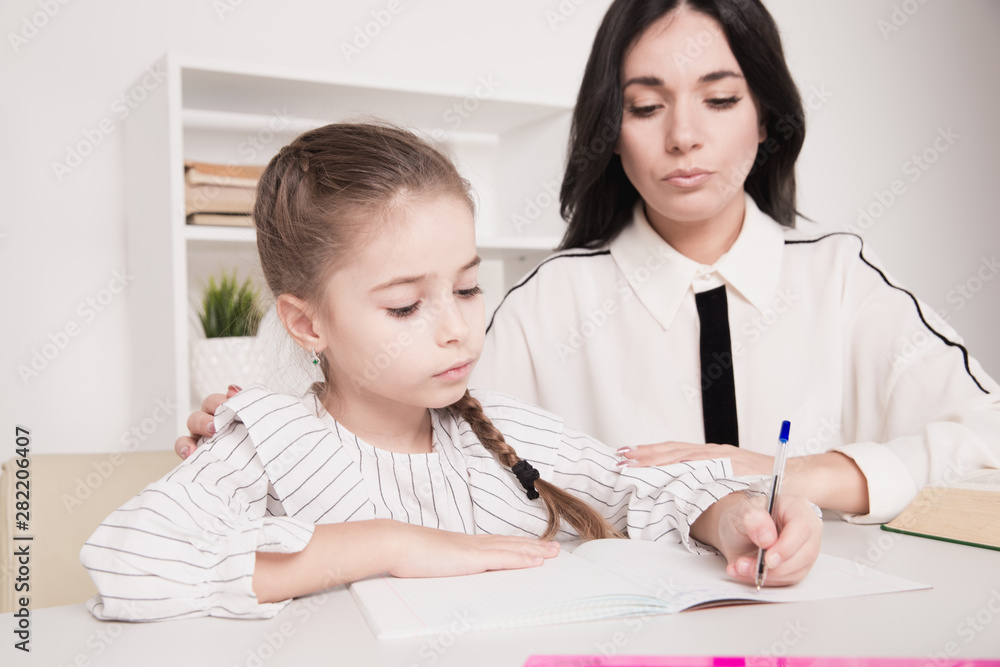 Mother with daughter studying at home. Homwschool concept Mother with daughter studying at home. Homwschool concept