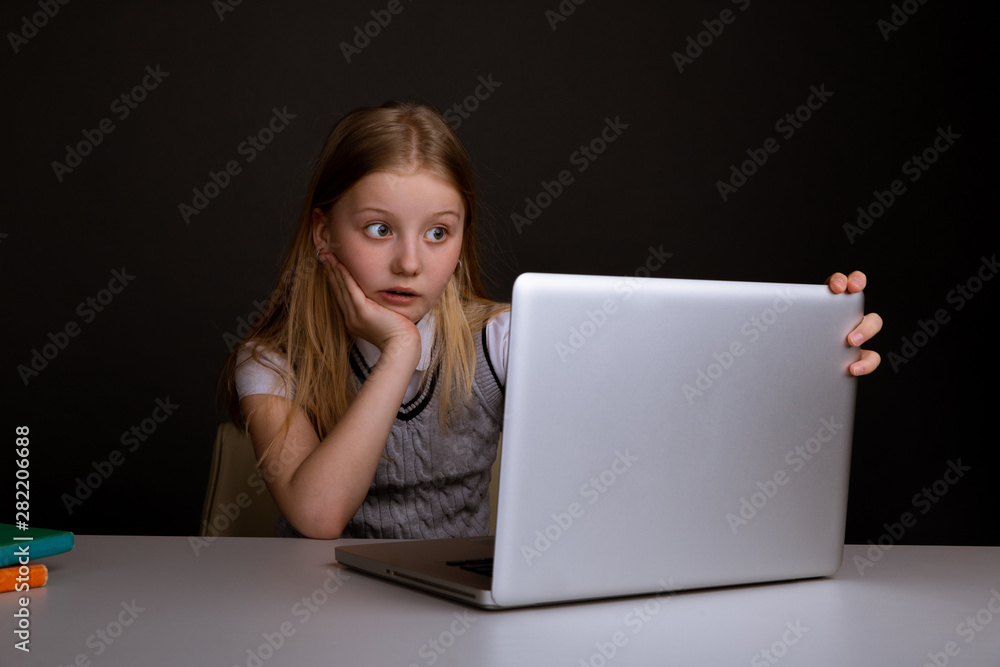 Bored little girl sitting infront of the computer. Feeling sick concept Bored little girl sitting infront of the computer. Feeling sick concept
