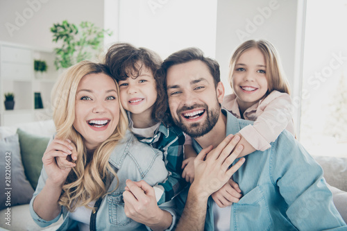 Photo of four family members after adoption having best time rejoicing sit couch living room indoors