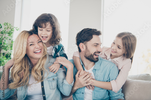 Photo of four family members after adoption spend time rejoicing giggle sit couch living room