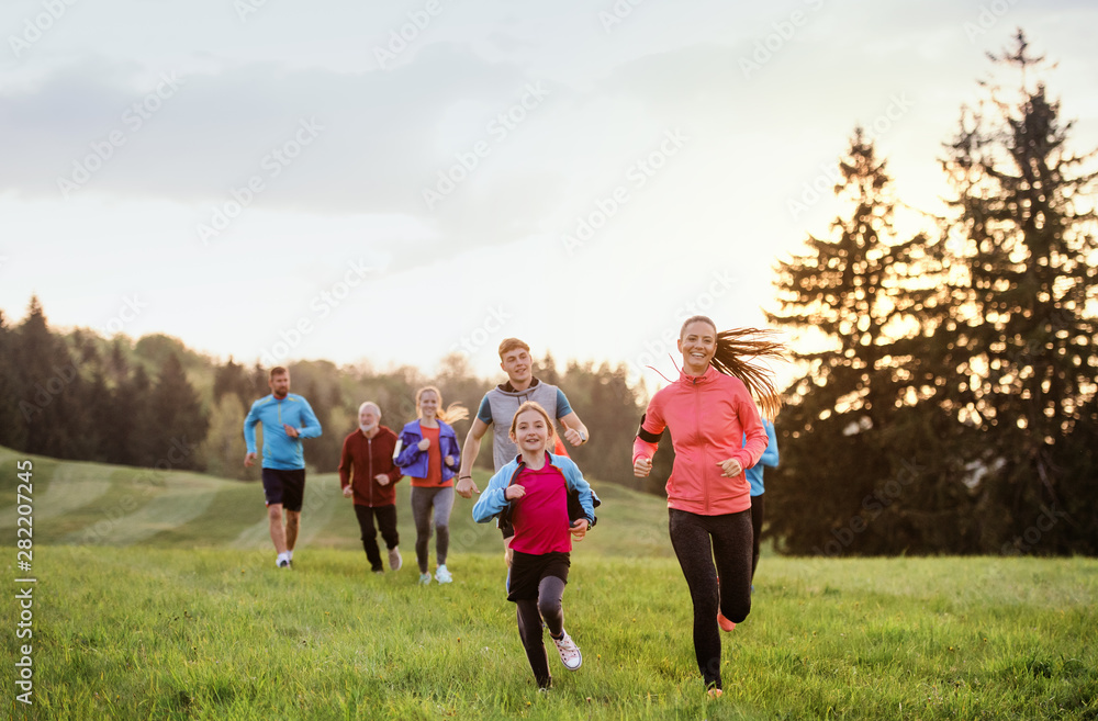 A large group of people cross country running in nature. A large group of people cross country running in nature.