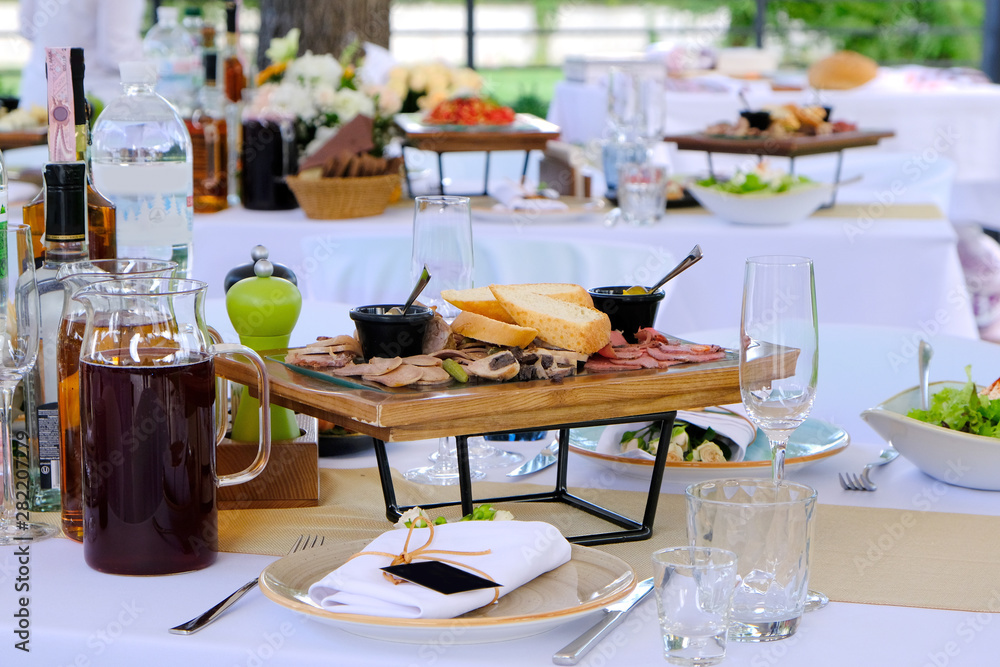 Delicious dishes on wooden trays and drinks on a banquet table in a restaurant.