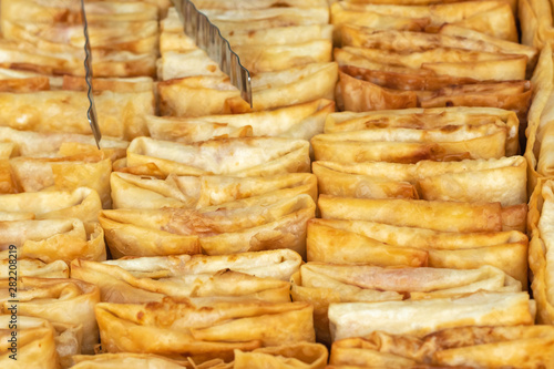 Fried flour roll for sale at the street food market, festival. Pancakes stuffed with different fillings, street food.