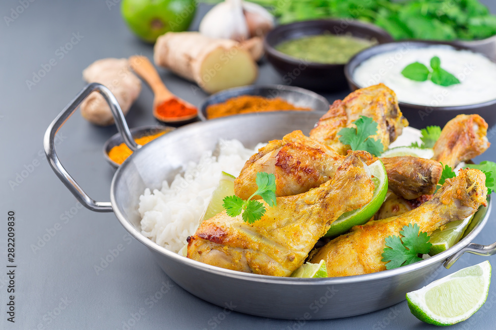 Indian chicken tandoori, marinated in greek yogurt and spices, served with lime wedges, cilantro and basmati rice, horizontal Indian chicken tandoori, marinated in greek yogurt and spices, served with lime wedges, cilantro and basmati rice, horizontal