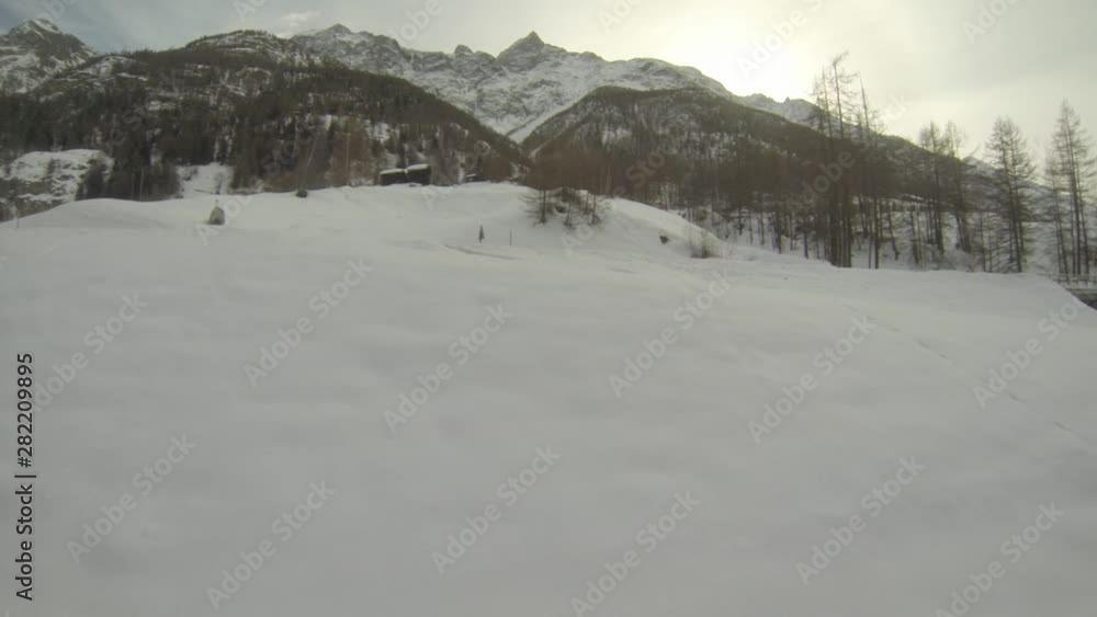 Train heading from Geneva to Zermatt passing a snow covered bridge, side window view of the landscape. Train heading from Geneva to Zermatt passing a snow covered bridge, side window view of the landscape.