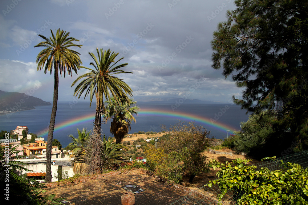 amazing rainbow on the sky in taormina sicilt tourists taking photos
