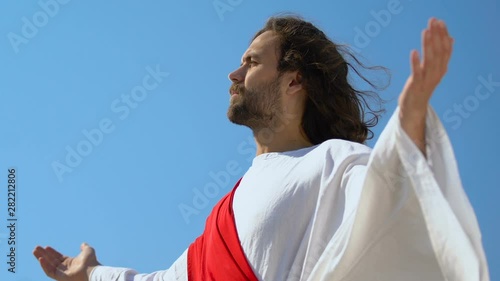 Resurrected Jesus raising hands in front of parishioners, Christian religion photo