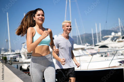 Fitness couple running training on beach. Morning cardio workout fit, sport concept