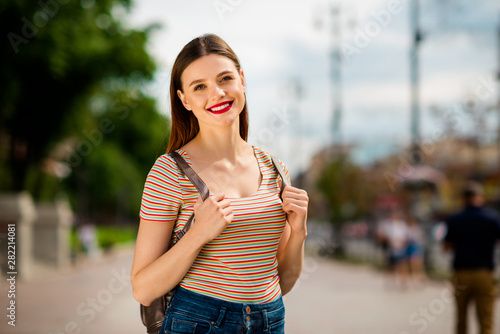 Portrait of charming youth smiling looking wearing denim jeans in town outside