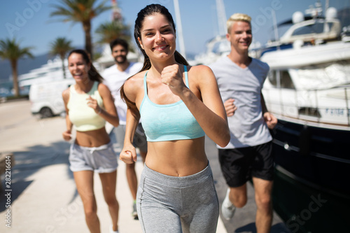 Happy fit people running and jogging together in summer sunny nature © NDABCREATIVITY