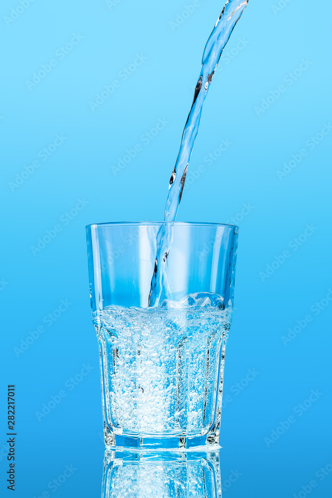 Close up pouring purified fresh drink water from the bottle on table Close up pouring purified fresh drink water from the bottle on table