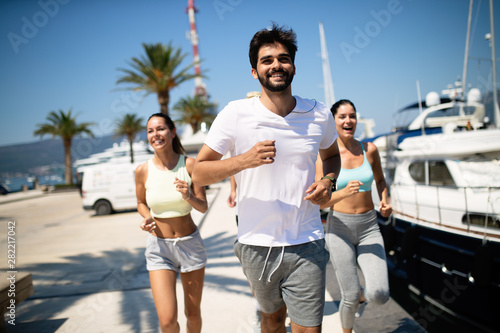 Healthy group of friends running and enjoying friend time together © NDABCREATIVITY