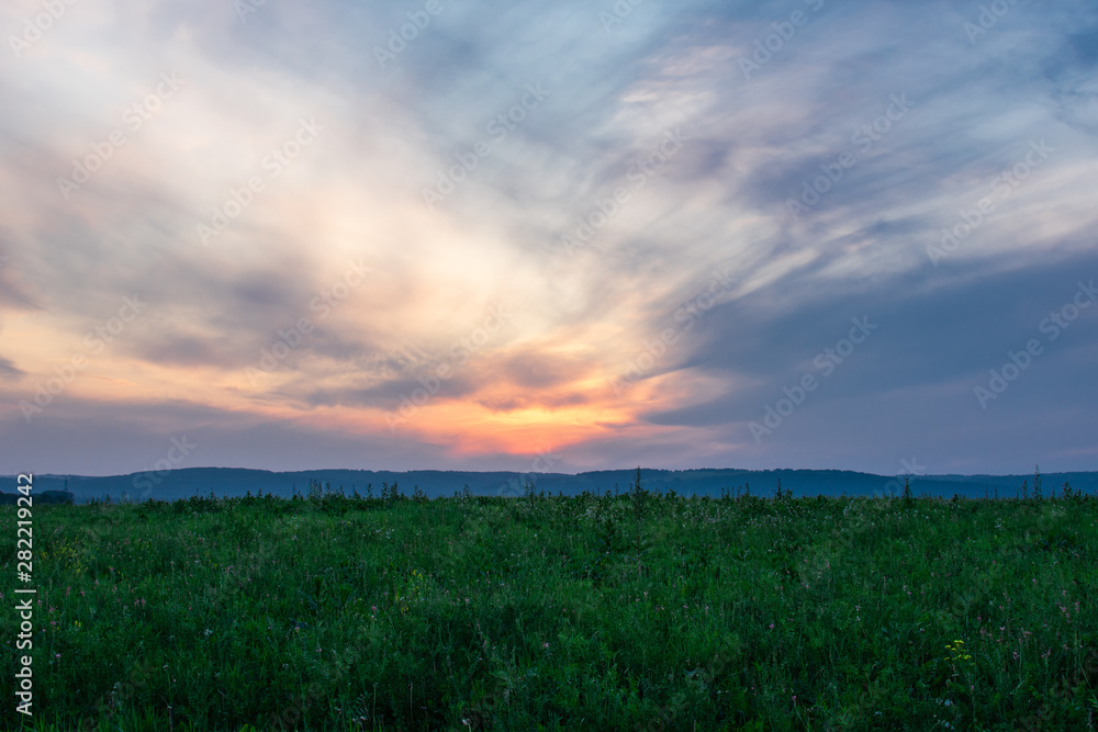 beautiful sunset over a green field