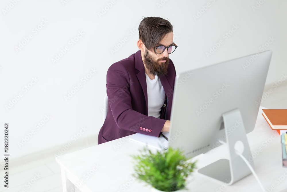 Fotografie People and technology concept - Man sits and works at the computer