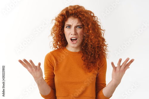 Angry outraged attractive, stylish redhead woman raising hands in dismay, complaining stare frustrated and furious, bothered bad service, shouting at manager, stand white background disappointed