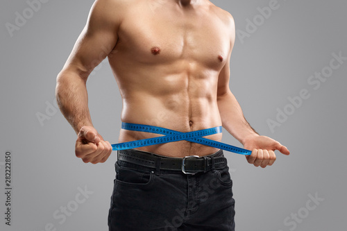Εκτύπωση καμβά Crop slim guy measuring waistline