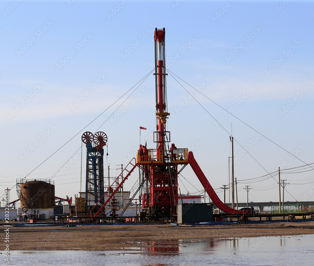 The pumping unit is operating in the oil field in the evening, silhouetted against the sky The pumping unit is operating in the oil field in the evening, silhouetted against the sky