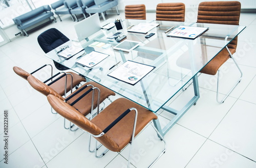 Desk for negotiations with the prepared financial charts and office equipment in the conference room before business meetings.