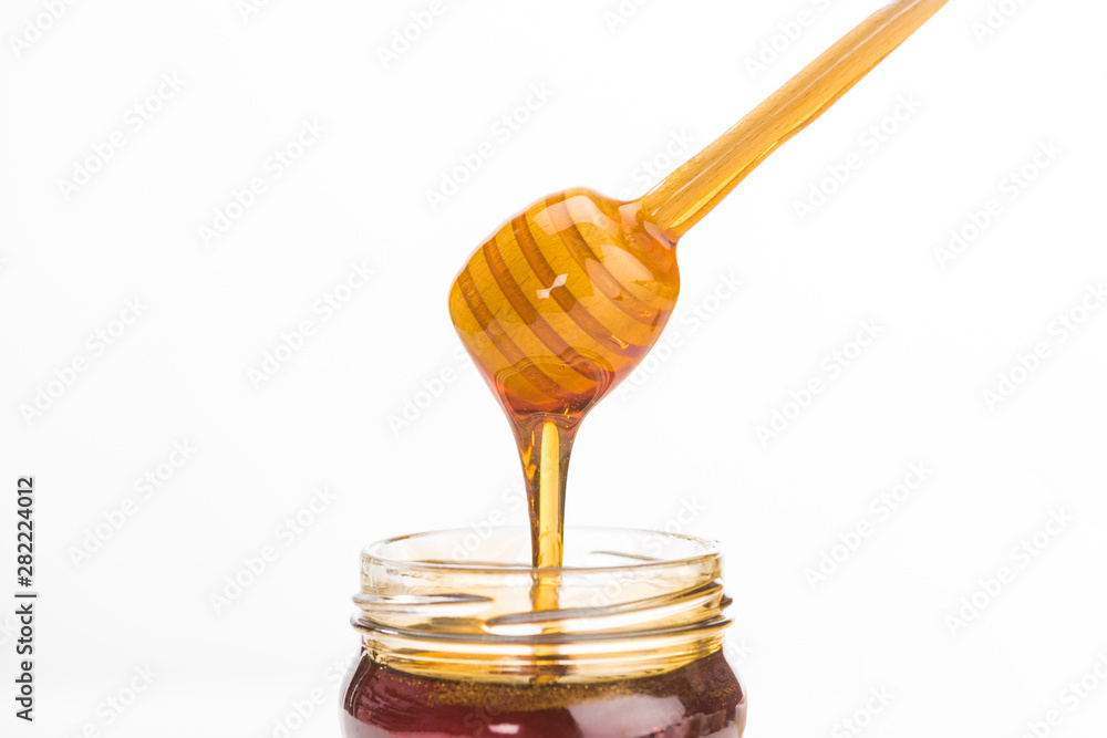 wooden honey dipper with dripping delicious honey isolated on white wooden honey dipper with dripping delicious honey isolated on white